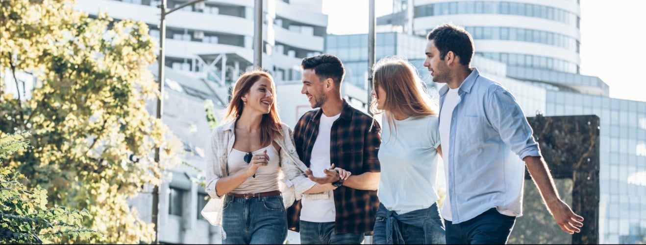 Un groupe de 4 personnes qui discutent et marchent